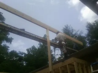 Carpenter setting a ridge beam over a new addition frame — Ice Dam Removal by Roofing Brothers in Newman Lake