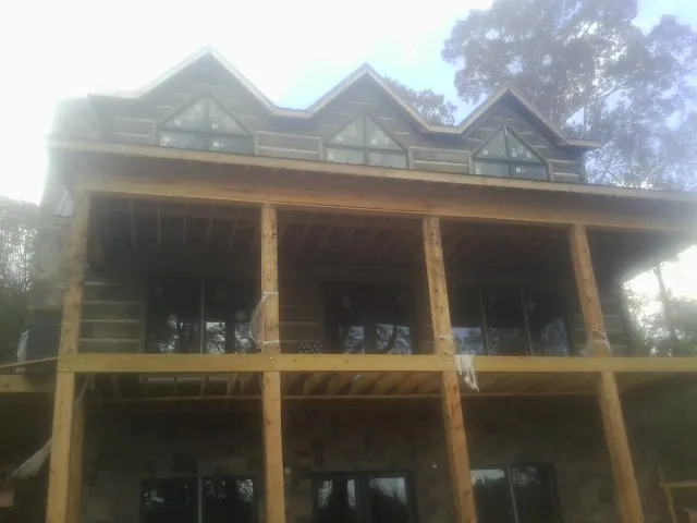 Dormers and porch framing on a large log home under construction — Roof Coating work by our crew in Newman Lake