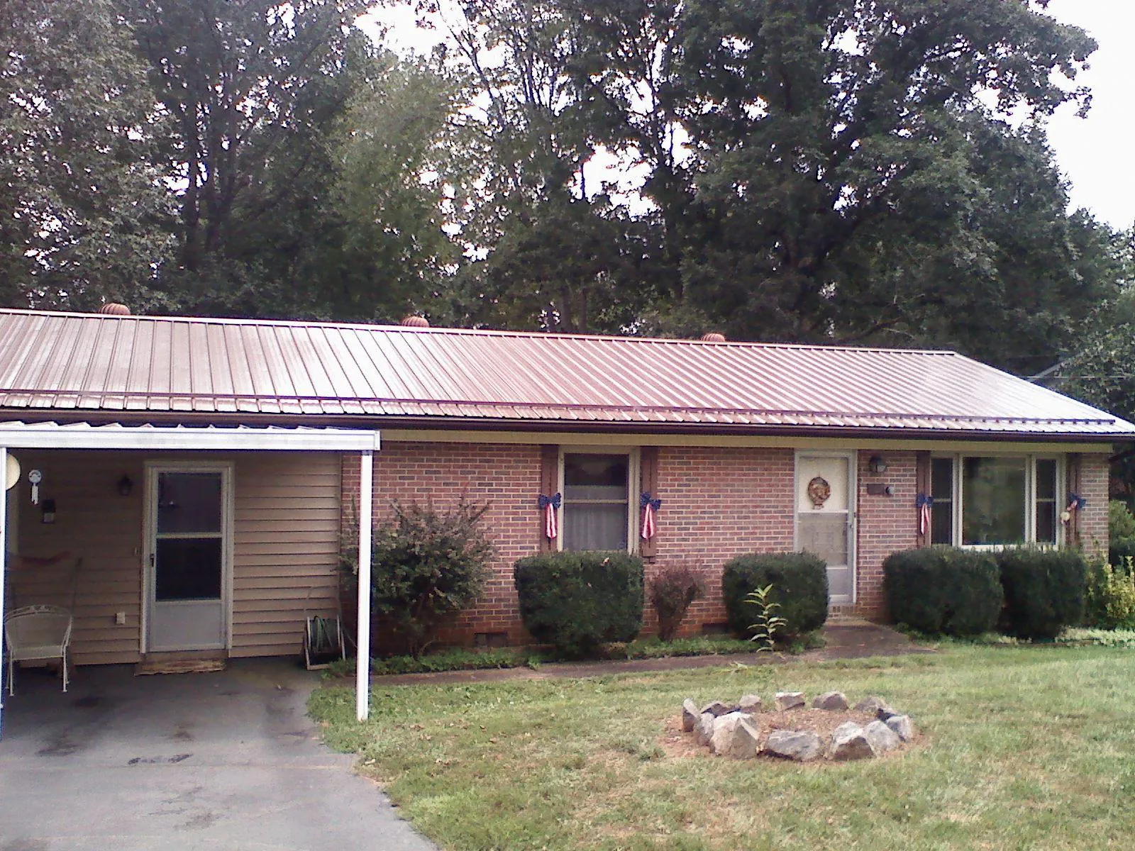 Bronze metal roof and carport on a brick ranch home — Roof Repair work by our crew in Newman Lake
